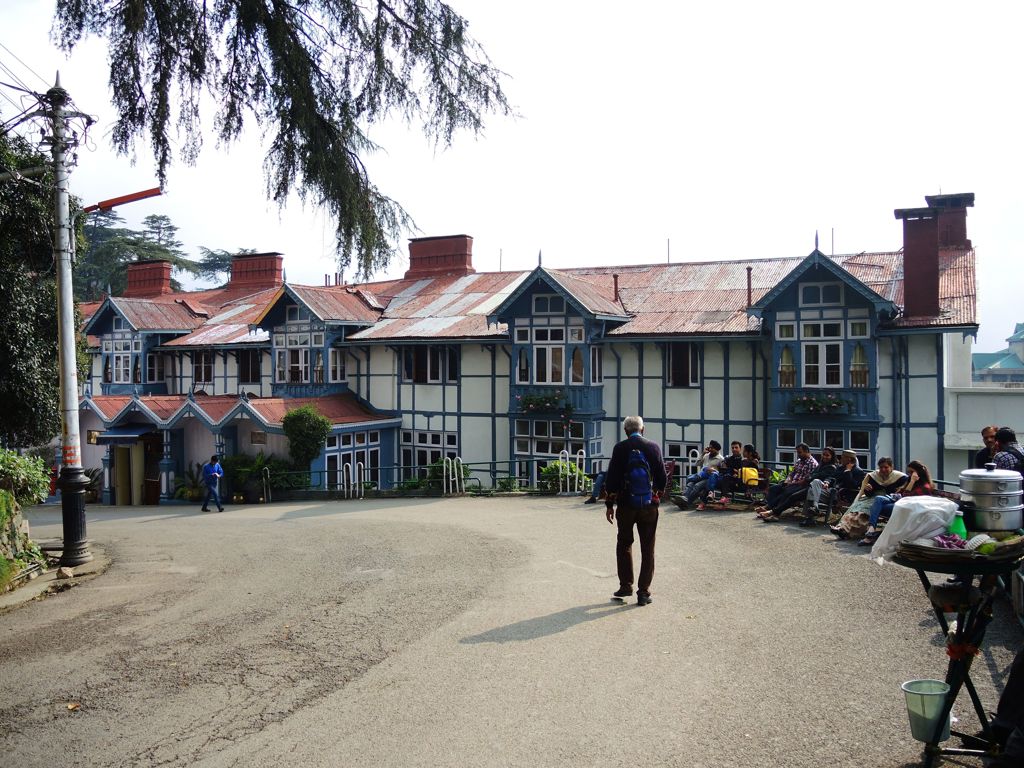 Wandelaar met rugzak bij koloniale gebouwen in Shimla, India, tijdens groepsrondreis Spiti & Ladakh.