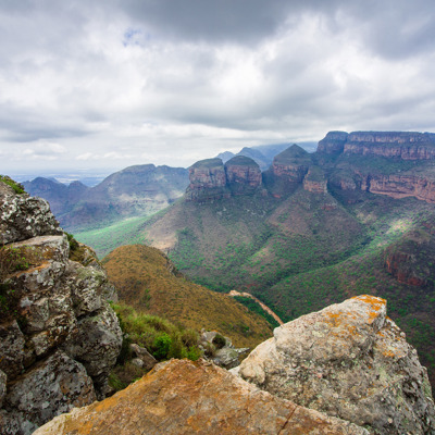 Uitzicht over de Blyde River Canyon en de Drie Rondavels in Zuid-Afrika onder een bewolkte lucht.