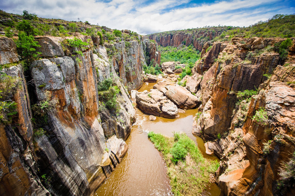 Uitzicht op een diepe kloof met steile rotswanden en een rivier, tijdens een rondreis door Zuid-Afrika, eSwatini en Lesotho.