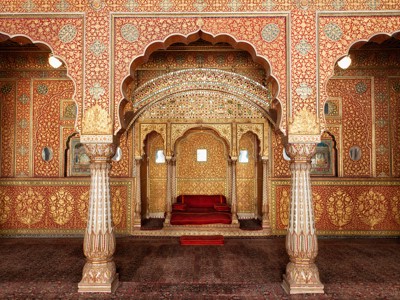 Goudrode, rijk versierde paleiszaal met bogen en troonzetel in Jaipur, Noord-India.