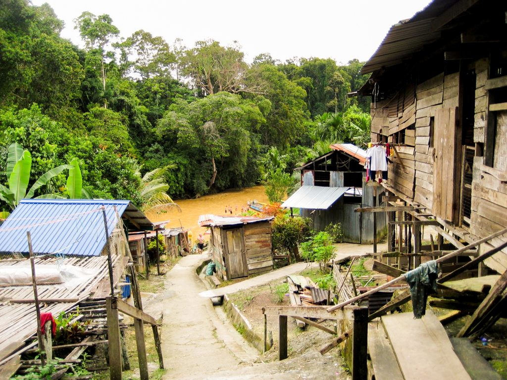 Houten huizen langs een rivier in het regenwoud van Maleisisch Borneo tijdens een familiereis.