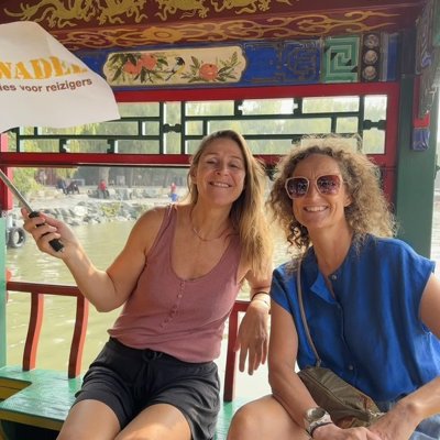 Reizigers op een boot in China tijdens groepsrondreis China, met Sawadee-vlag.