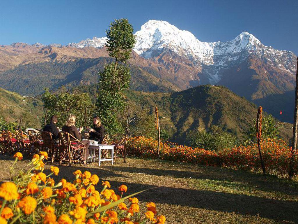 Reizigers genieten van het uitzicht op besneeuwde Himalaya-bergen tijdens een groepsrondreis Nepal.