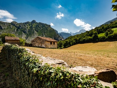 Landelijke wandelroute langs stenen boerderijen en groene bergen in de Picos de Europa, Spanje.