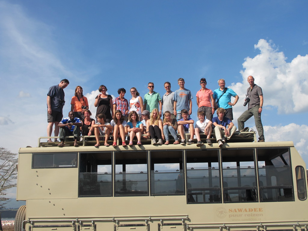 Groep families op het dak van een safaritruck tijdens familiereis Tanzania en Zanzibar.
