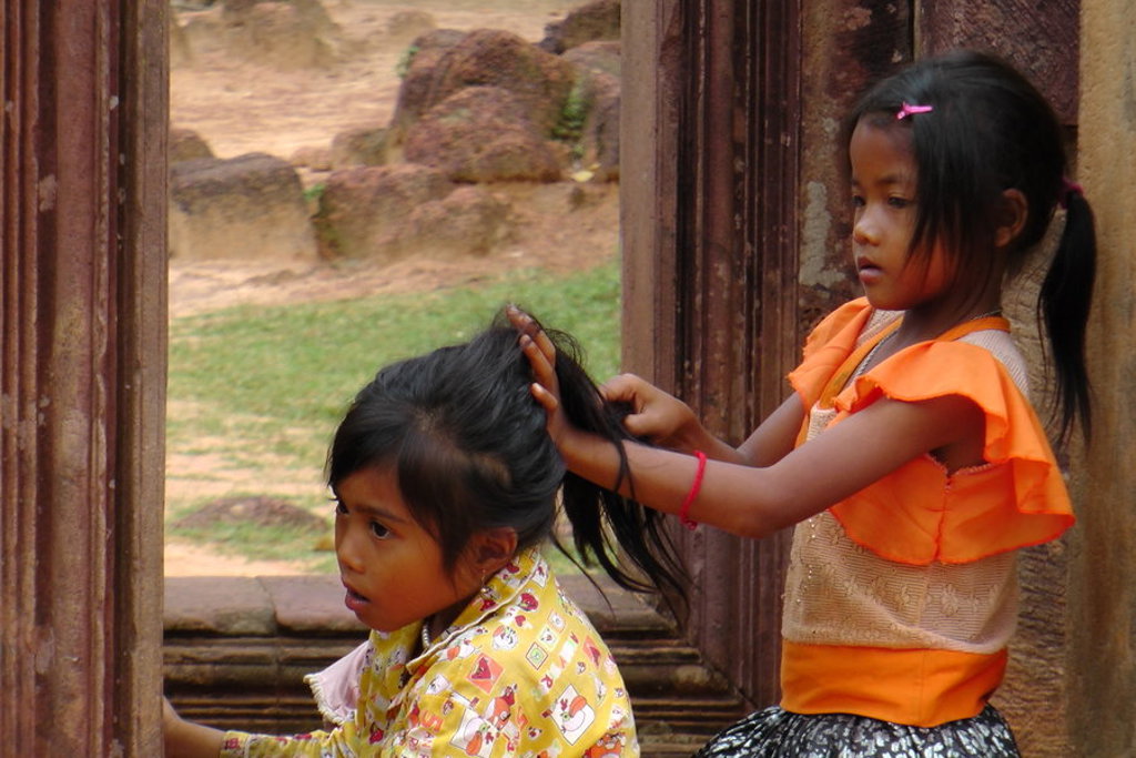 Twee kinderen spelen bij een tempelruïne tijdens fietsvakantie Vietnam, Cambodja en Thailand.