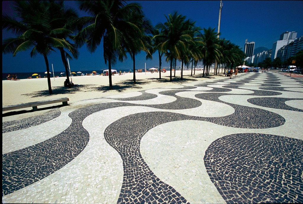 Boulevard met golvend mozaïek en palmbomen langs Copacabana in Rio de Janeiro, Brazilië.