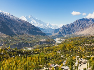 Panorama van de Hunza-vallei in Baltistan, Pakistan, met rivier, herfstbomen en besneeuwde bergtoppen.