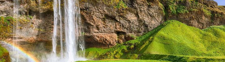 Seljalandsfoss waterval in IJsland, met water dat langs een groene klif naar beneden stort.