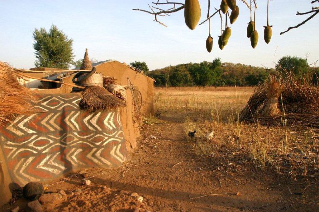 Traditionele lemen hut met beschilderde muur in het savannelandschap van Ghana, Togo en Benin.