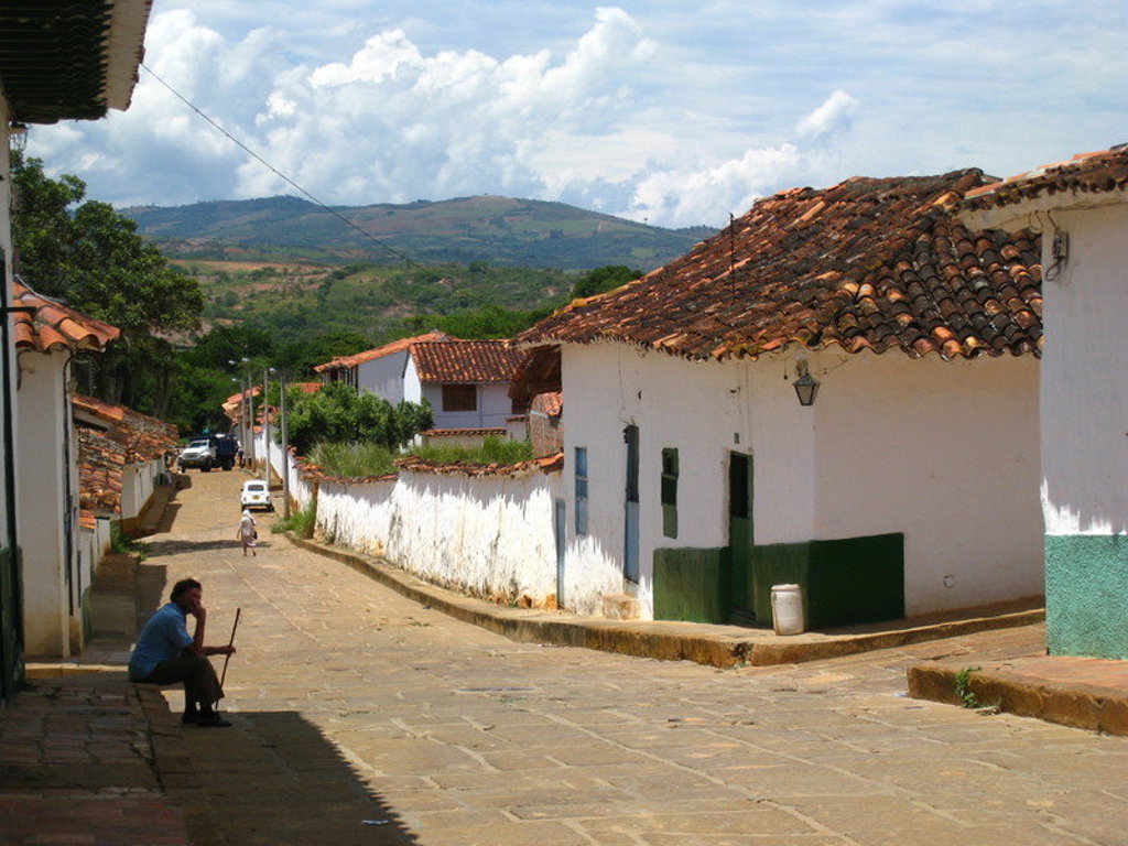 Rustige straat met witgekalkte huizen en rode dakpannen in Colombia, tijdens een familiereis.