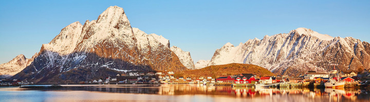 Sneeuwbergen en rood vissersdorp aan een fjord in Scandinavië.