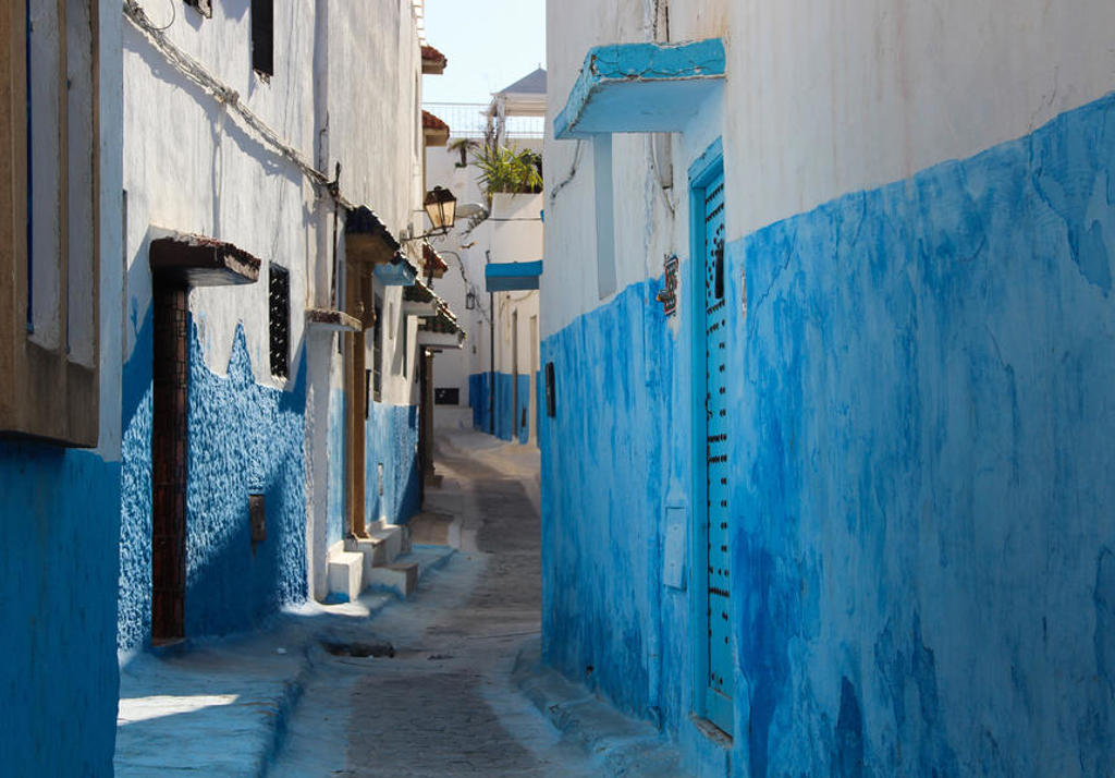 Smalle straat in Chefchaouen met wit-blauwe huizen, tijdens de premium groepsrondreis Marokko.