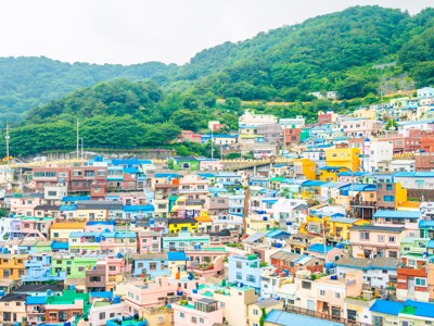 Kleurrijke huizen in Gamcheon Culture Village in Busan, Zuid-Korea, tegen groene heuvels.