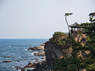 Paviljoen op rotsachtige kust met pijnbomen en uitzicht op zee in Zuid-Korea.