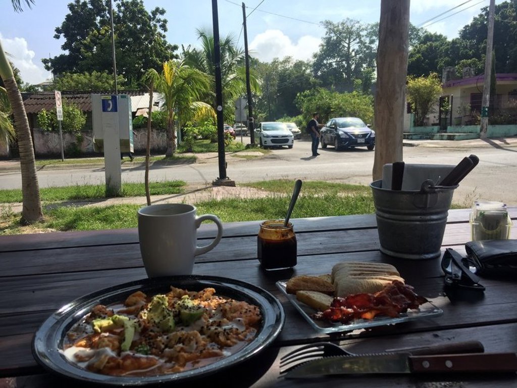 Ontbijt met koffie en Mexicaanse gerechtjes op een terras langs de weg tijdens een groepsrondreis door Mexico.