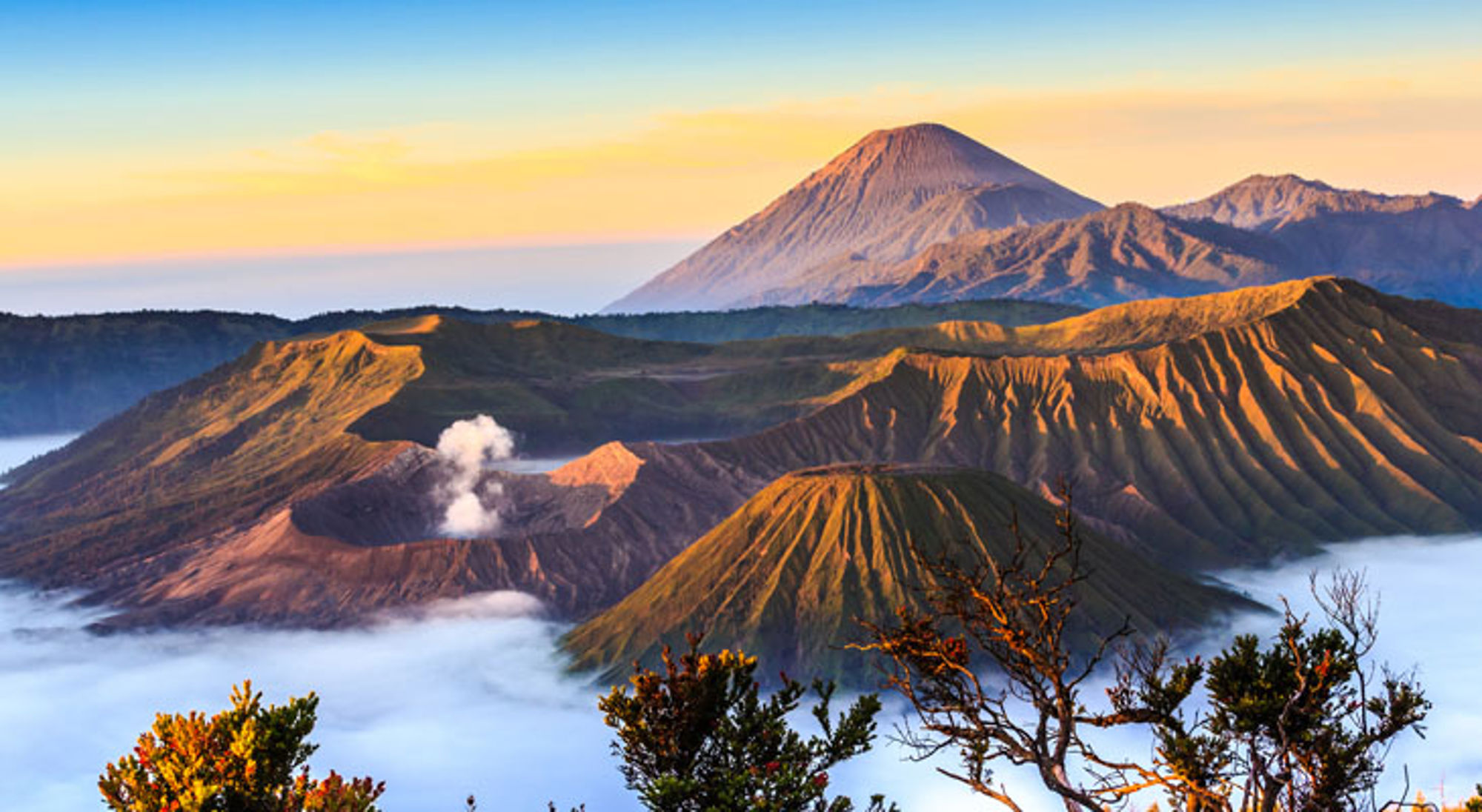 Zonsopgang boven de Bromo-vulkaan en omliggende kraters in Indonesië, met nevel in de vallei.