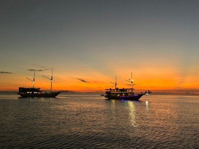 Twee boten op zee bij zonsondergang tijdens de Route Kleine Sunda Eilanden.
