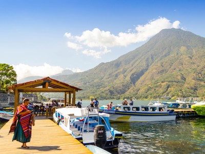 Booten aan de steiger op het Meer van Atitlán met een vulkaan op de achtergrond, route Guatemala en Belize.