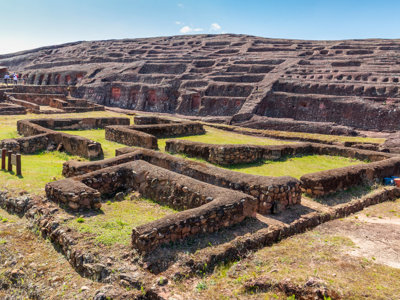 Terrasvormige archeologische ruïnes met lage stenen muren in Bolivia op de route Bolivia en Chili.