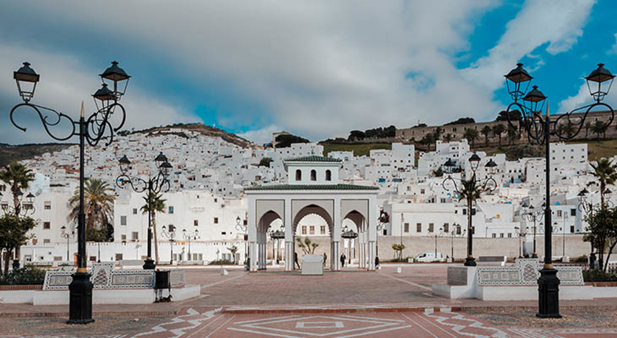 Uitzicht op Chefchaouen met witte huizen en stadspoort op een plein in Marokko.