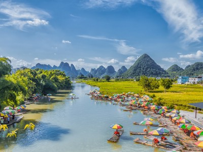 Bamboevlotten met kleurrijke parasols op de rivier bij karstbergen in Guilin, China.