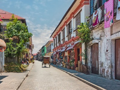 Straatbeeld in Vigan met kleurrijke koloniale huizen, winkels en een kalesa tijdens de Route Filipijnen.