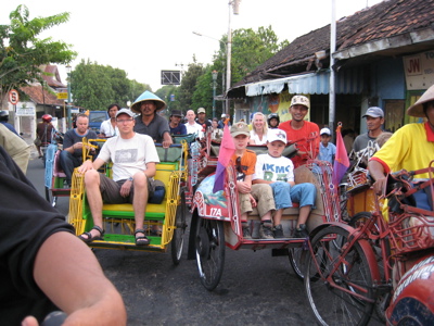Gezin in kleurrijke becak-fietstaxi’s op straat in Java tijdens de Familiereis Java & Bali.