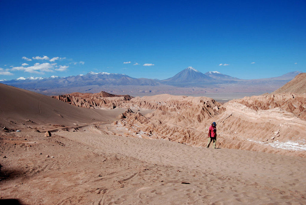 Wandelaar in de Valle de la Luna bij San Pedro de Atacama, met vulkanen op de achtergrond in Chili.
