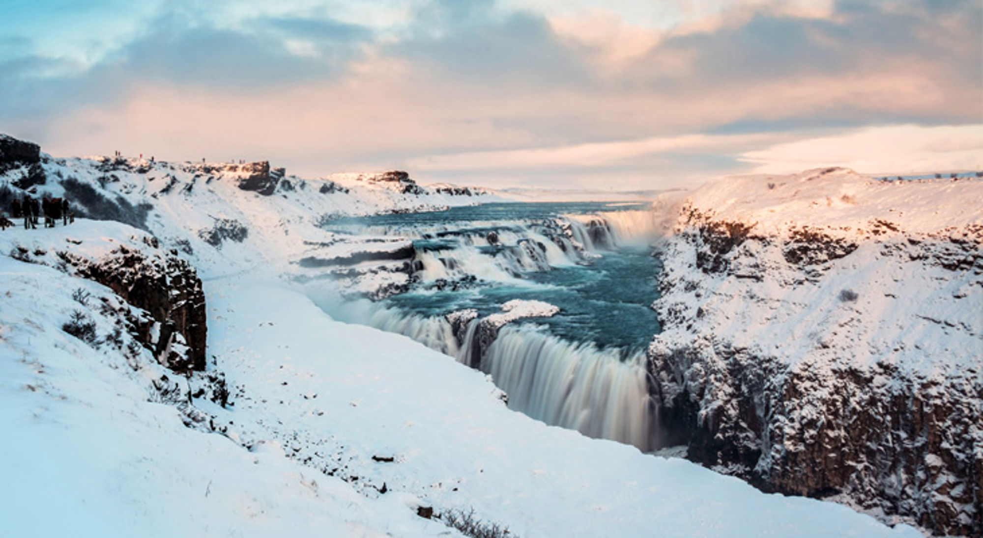 Gullfoss-waterval in IJsland, met besneeuwde kliffen en een brede rivierkloof.
