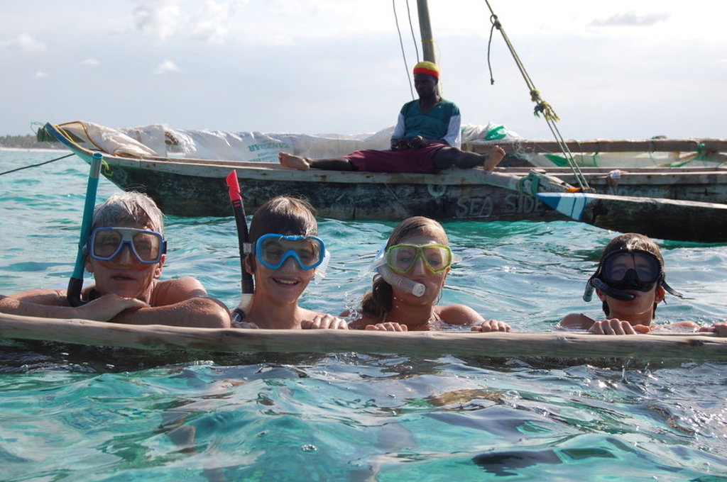 Gezin snorkelt in helderblauw water bij Zanzibar tijdens familiereis Tanzania en Zanzibar.