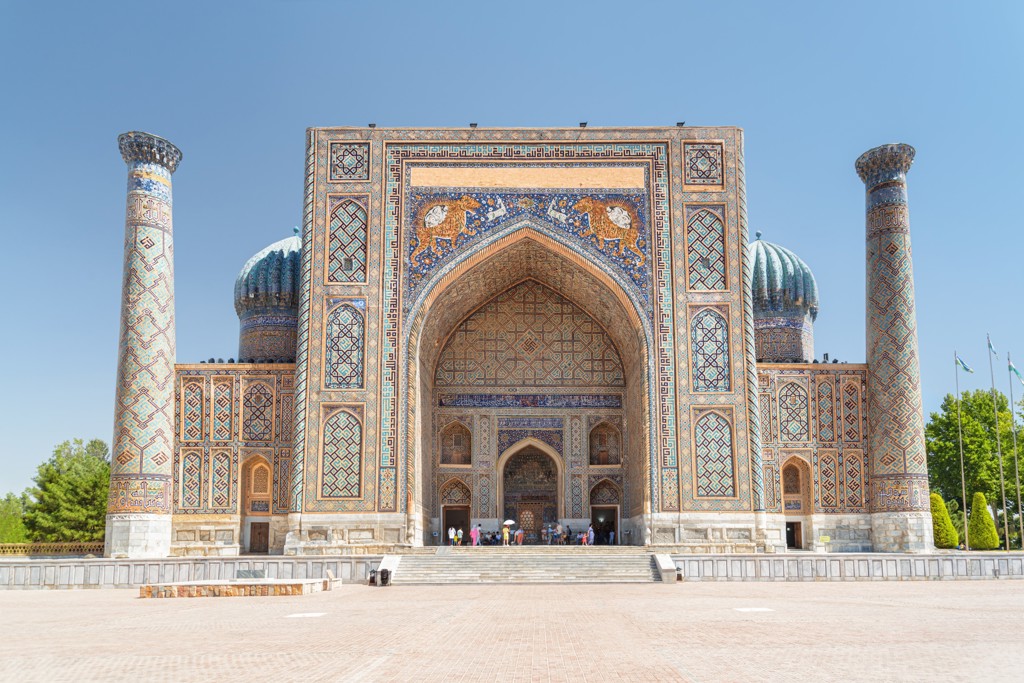 Registan-plein in Samarkand met kleurrijke mozaïeken en hoge minaretten, stop op de Zijderoute met de trein.