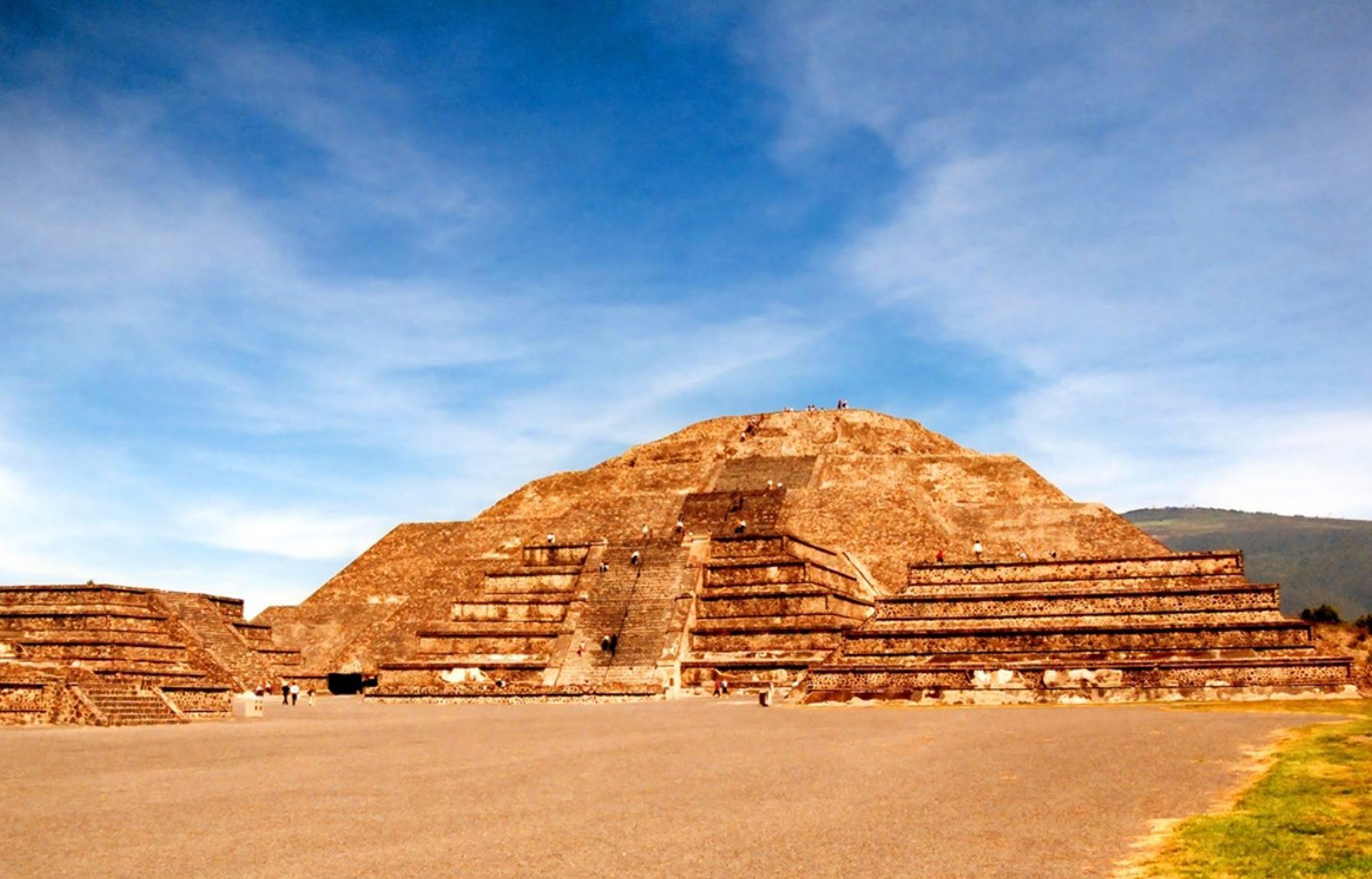 Piramide van de Zon in Teotihuacan, Mexico, met brede trappen onder een blauwe lucht.