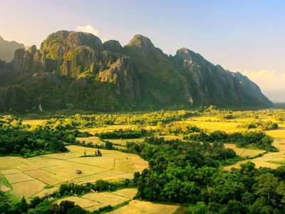 Karstbergen en rijstvelden bij Vang Vieng in Laos tijdens de rondreis Thailand, Laos en Cambodja.