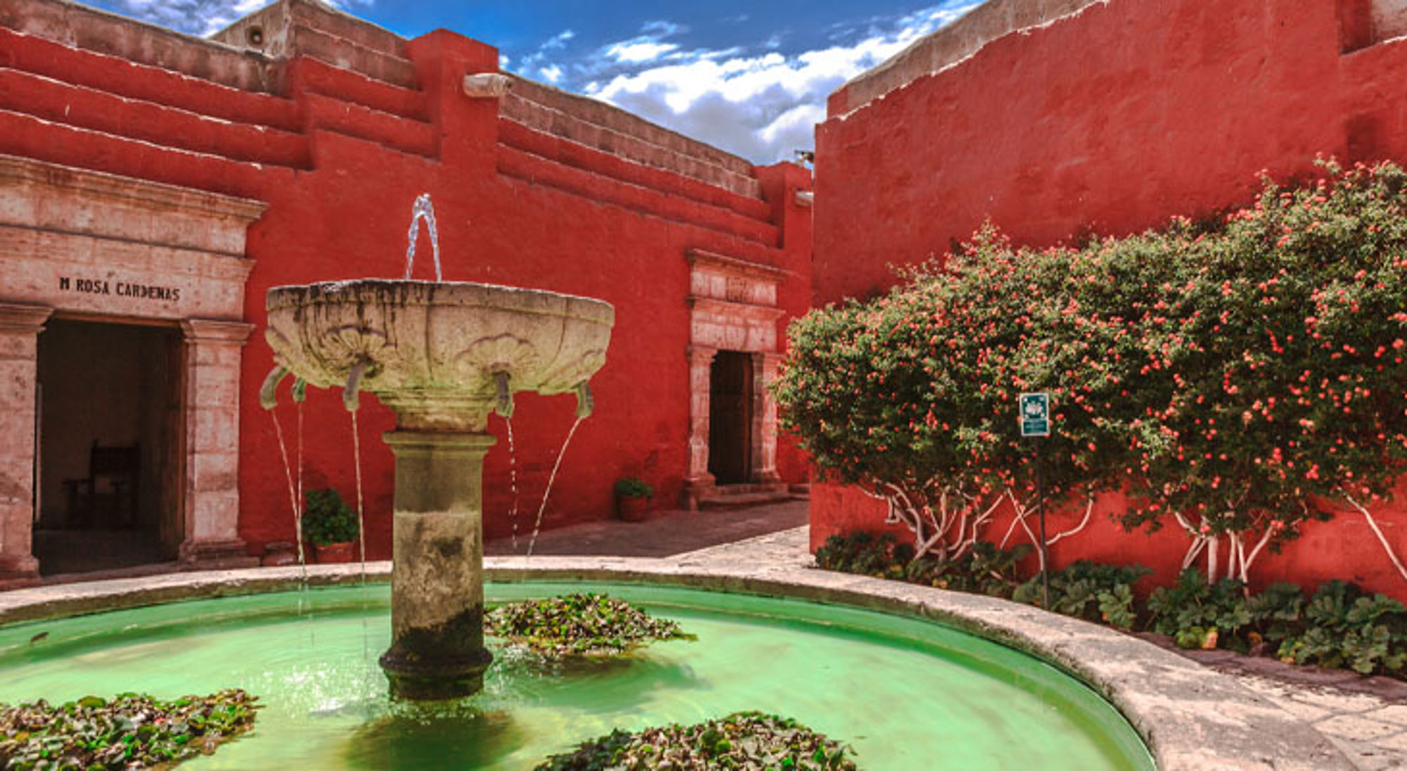 Santa Catalina klooster Arequipa Fontein in het Santa Catalina-klooster in Arequipa, Peru, met rode muren en groene waterbassin.
