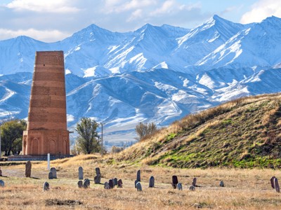 Burana-toren bij Tokmok met besneeuwde bergen op de achtergrond, Route Kirgistan.