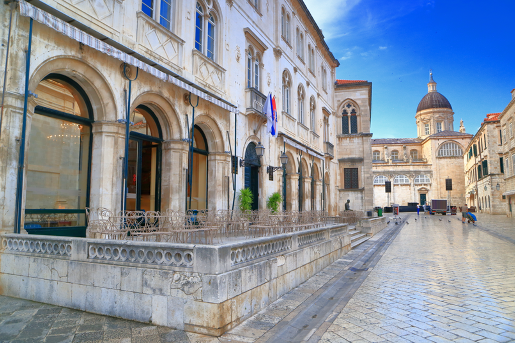 Historisch plein in Dubrovnik met arcades en koepelkerk, tijdens fietsvakantie Balkan.