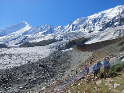 Wandelaars langs een gletsjer met besneeuwde bergtoppen in Baltistan, Pakistan.