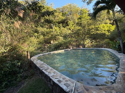 Thermaal bad bij Cañon de la Vieja Lodge in Costa Rica, omringd door tropisch groen.