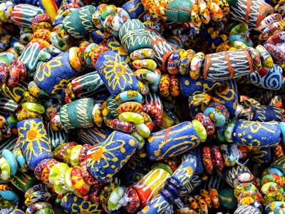 Kleurrijke kralenarmbanden en glaskralen op een markt tijdens de reisroute Ghana, Togo en Benin.