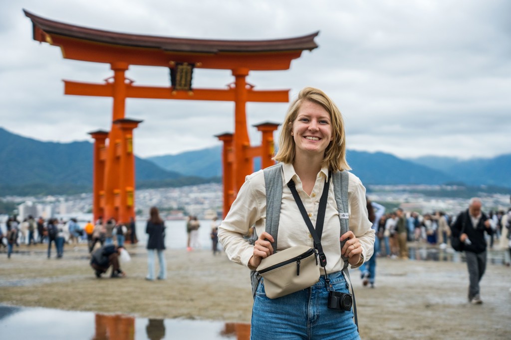 Jonge reiziger bij de grote rode torii-poort op Miyajima, tijdens 22-35ers reis Japan.