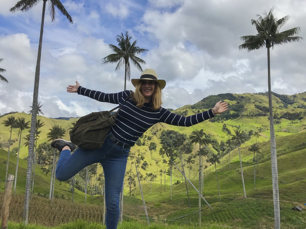 Reiziger in de Cocoravallei tussen hoge palmbomen en groene heuvels tijdens een familiereis Colombia.