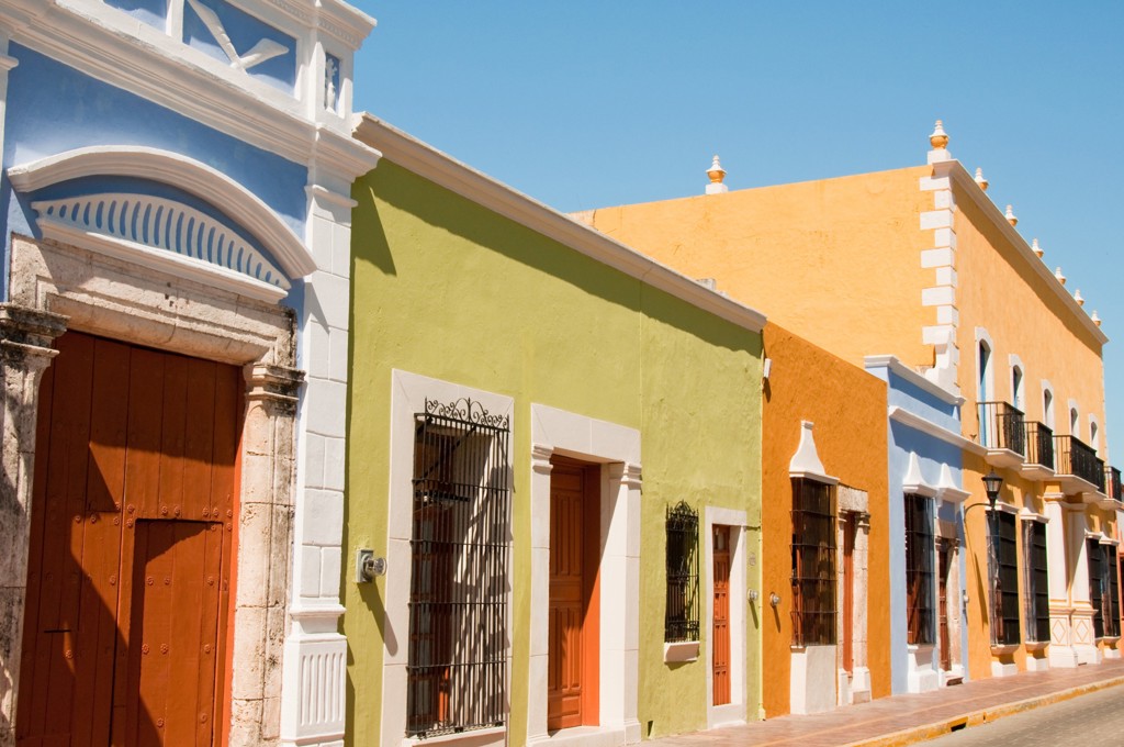 Kleurrijke koloniale gevels en deuren in een straat in Mexico tijdens een familiereis langs hoogtepunten.