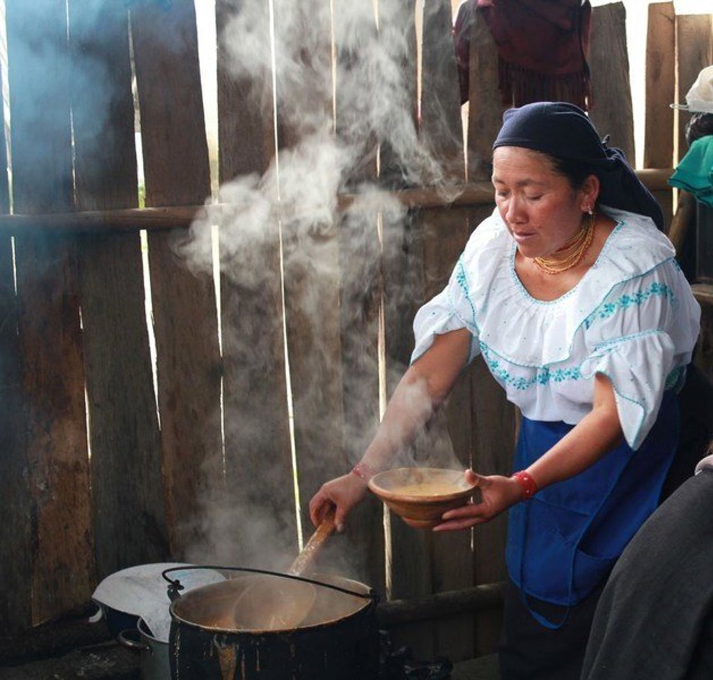 Vrouw bereidt een warme maaltijd in een keuken in Ecuador tijdens een groepsrondreis met optioneel Galapagos.