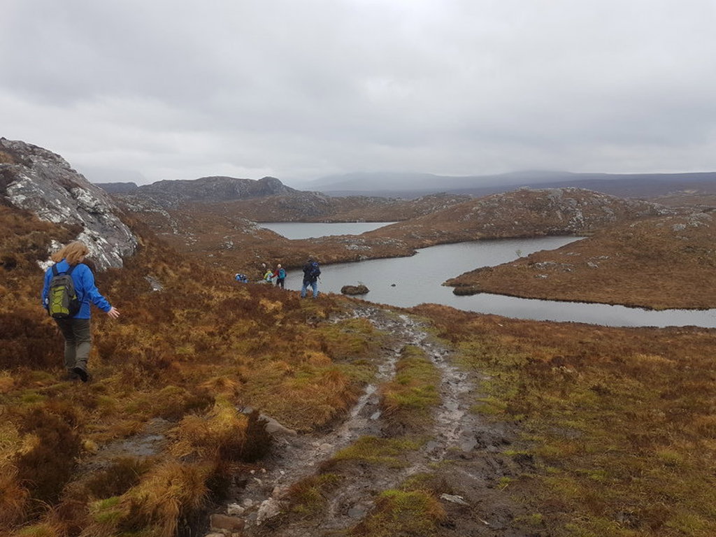 Wandelaars langs een loch in de Schotse Hooglanden tijdens een groepsrondreis Schotland.