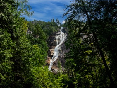 Waterval in een groen naaldbos langs de Route Canada.