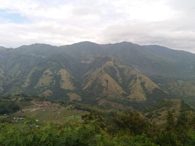 Groene bergketen met valleien en rijstvelden tijdens de Route Sulawesi.