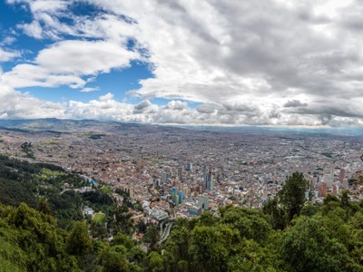 Panoramisch uitzicht over Bogotá vanaf de bergen, met wolkenlucht en de stad in de vallei.