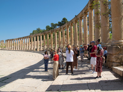 Groepsrondreis langs de Romeinse zuilengalerij op het Oval Plaza in Jerash, Jordanië.