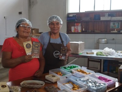 Vrouwen in een chocoladefabriek tonen verpakte bonbons en repen tijdens de Route Noord-Peru, dag 3.